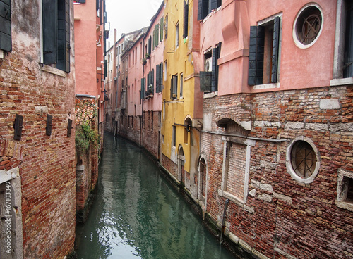 small canal in venice with old buildings balconies a fading painted walls © Philip J Openshaw 