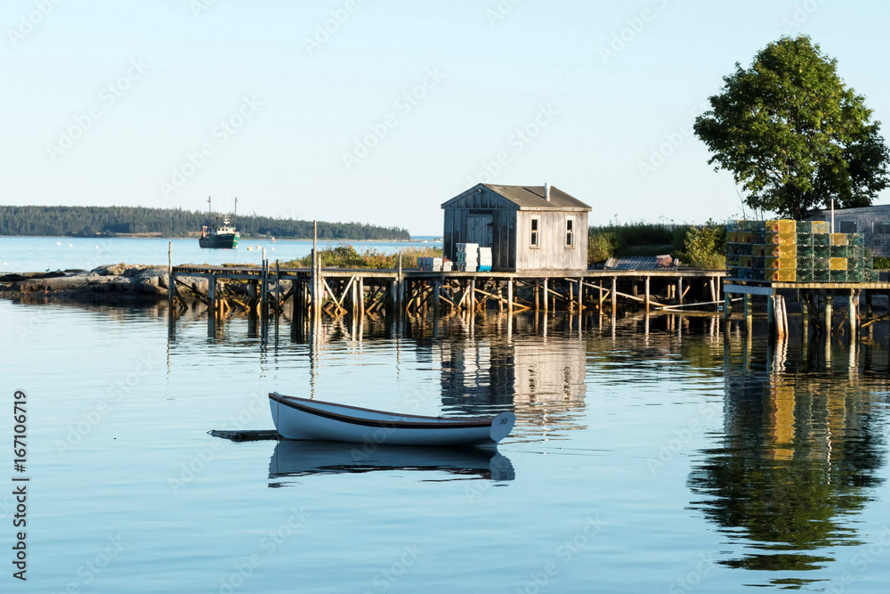 View of Bass Harbor with row boat, dock, labster traps, and fishing boat