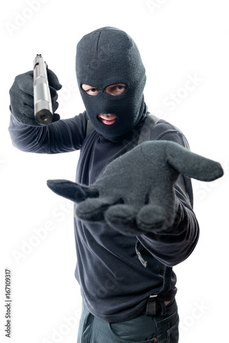 Fototapeta Armed robber requires money and aims at the camera