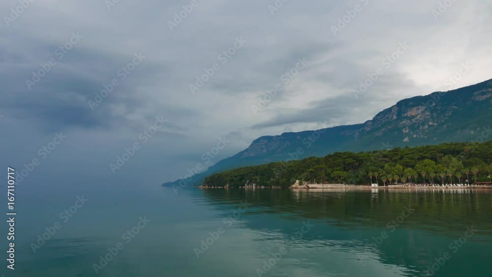 Partial view of Akyaka shoreline (Gulf of Gokova, Mugla, Turkey) on a very calm, hazy day. Color of the sea blends into the color of the sky at the horizon.
Partial view of Akyaka shoreline (Gulf of Gokova, Mugla, Turkey) on a very calm, hazy day. Color of the sea blends into the color of the sky at the horizon.
