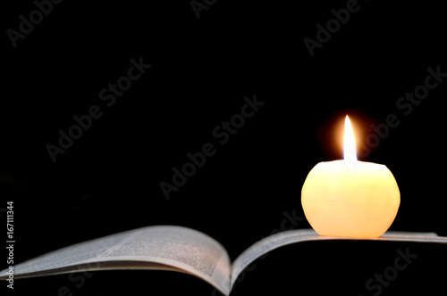 Funeral candle. Sympathy card with burning candle and open book isolated on black background