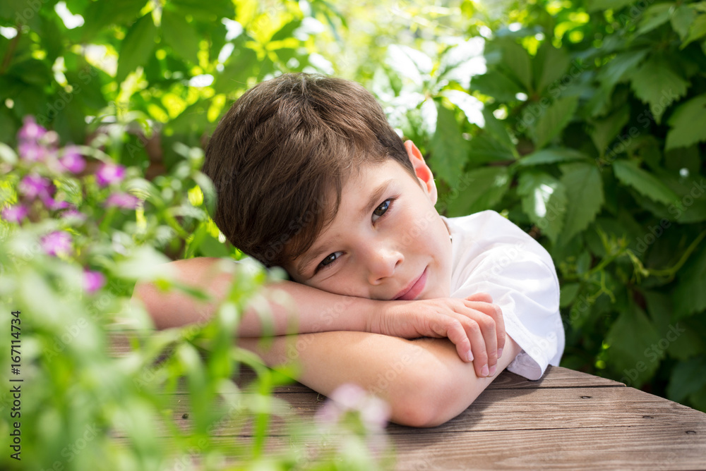 Boy on a background of green foliage Boy on a background of green foliage