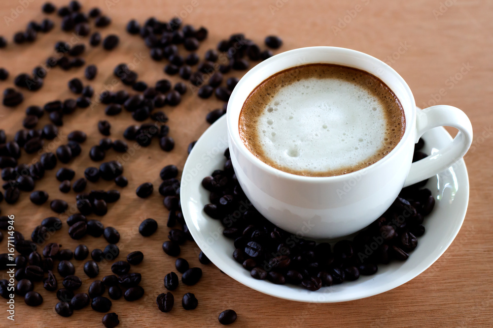 Hot coffee in white cup and coffee beans on the table Hot coffee in white cup and coffee beans on the table
