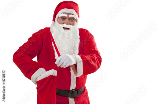 Portrait of Santa Claus removing gift from bag over white background 