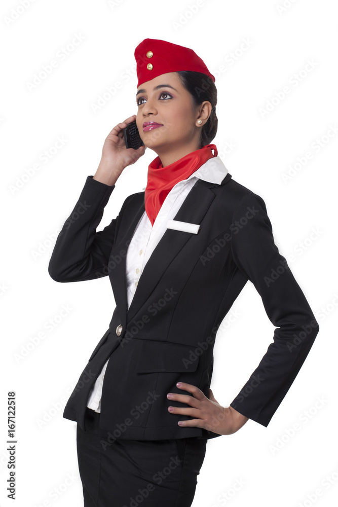 Young airhostess using cell phone while looking up isolated over white background Young airhostess using cell phone while looking up isolated over white background