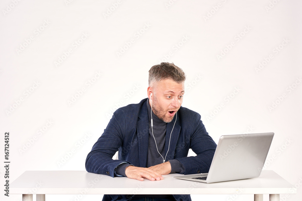 Portrait of middle-aged businessman sitting at office desk and having video call Portrait of middle-aged businessman sitting at office desk and having video call