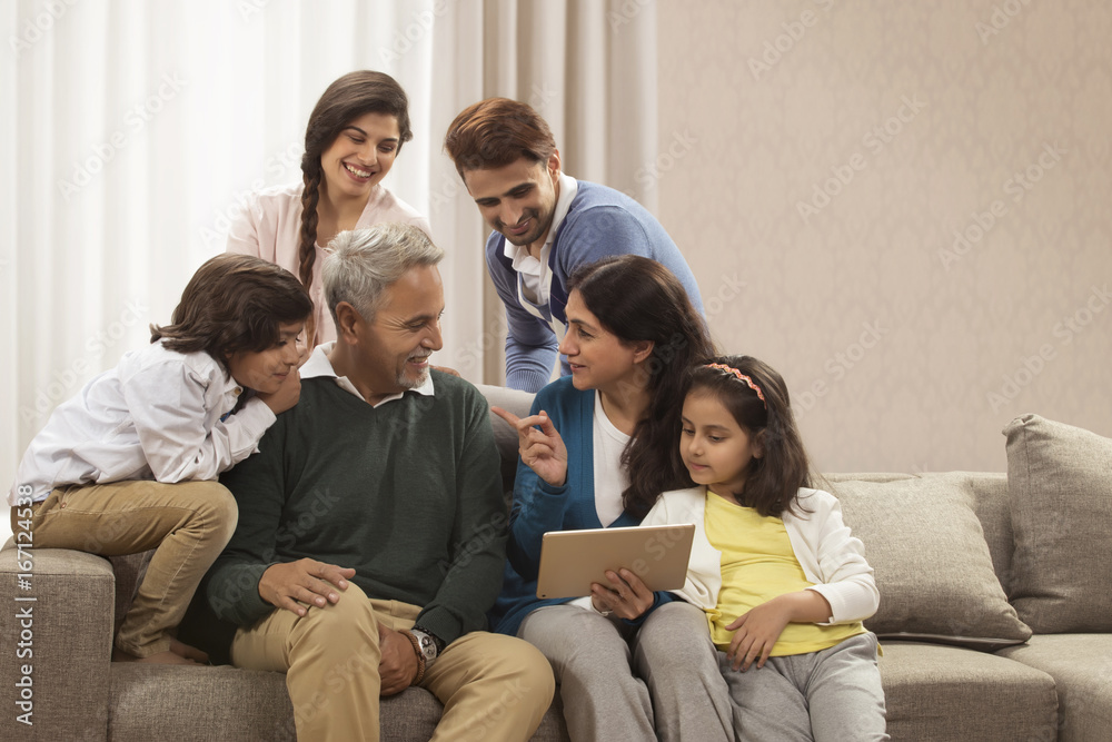 Happy multi generation family looking at digital tablet Happy multi generation family looking at digital tablet