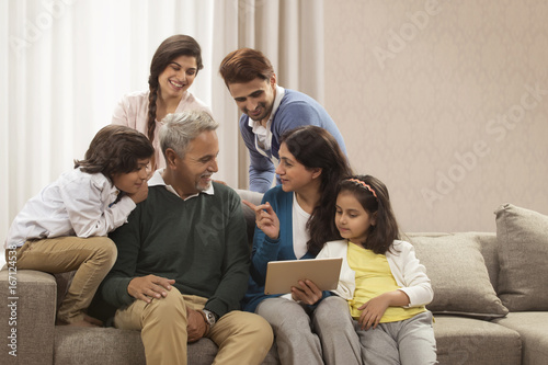 Happy multi generation family looking at digital tablet