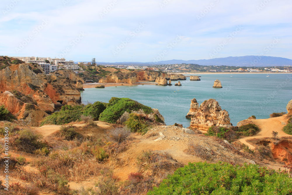 Beautiful landscape overlooking Atlantic ocean coast in Lagos, south Portugal. Summer nature panoramic scene: hills, water, beach and blue sky background. Photo of long distance outdoor sunny day