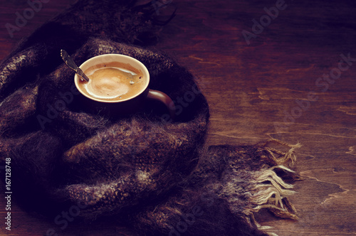 Hot coffee in warm scarf