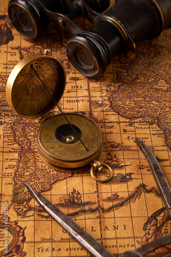 Old vintage retro compass on ancient world map. Vintage still life. Travel geography navigation concept background.