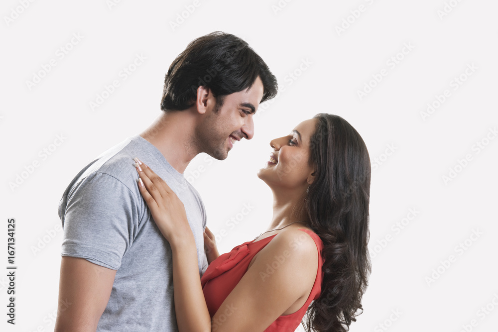 Side view of happy young couple against white background Side view of happy young couple against white background
