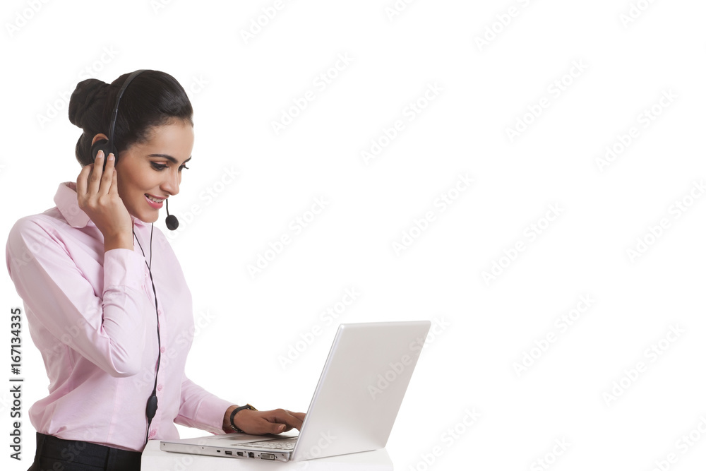 Indian businesswoman using headset and laptop over white background Indian businesswoman using headset and laptop over white background