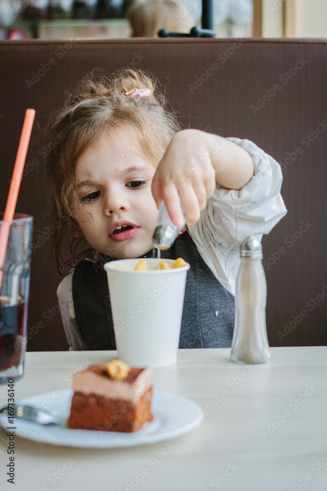 Little girl eating french fries on restaurant. Little girl eating french fries on restaurant.