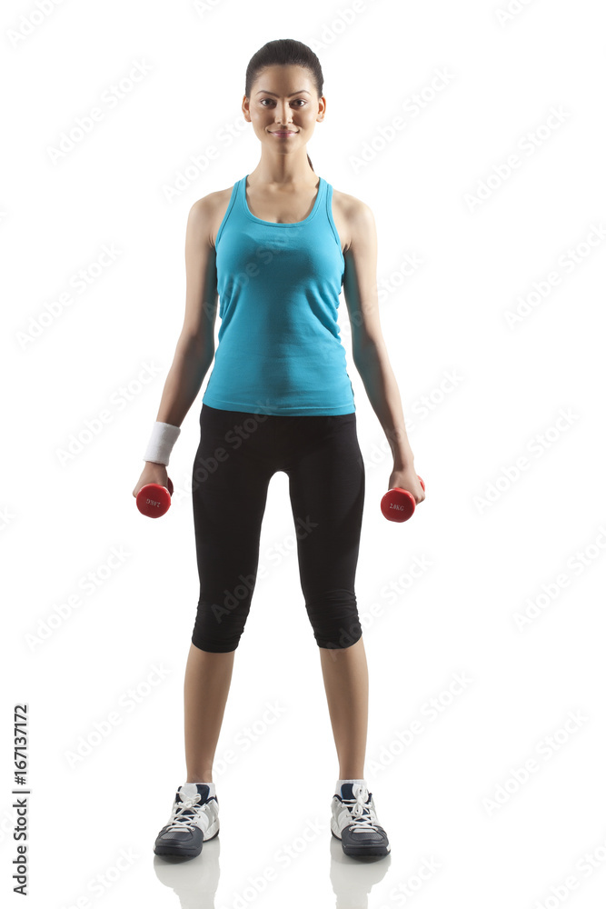 Portrait of young woman exercising with dumbbells isolated over white background