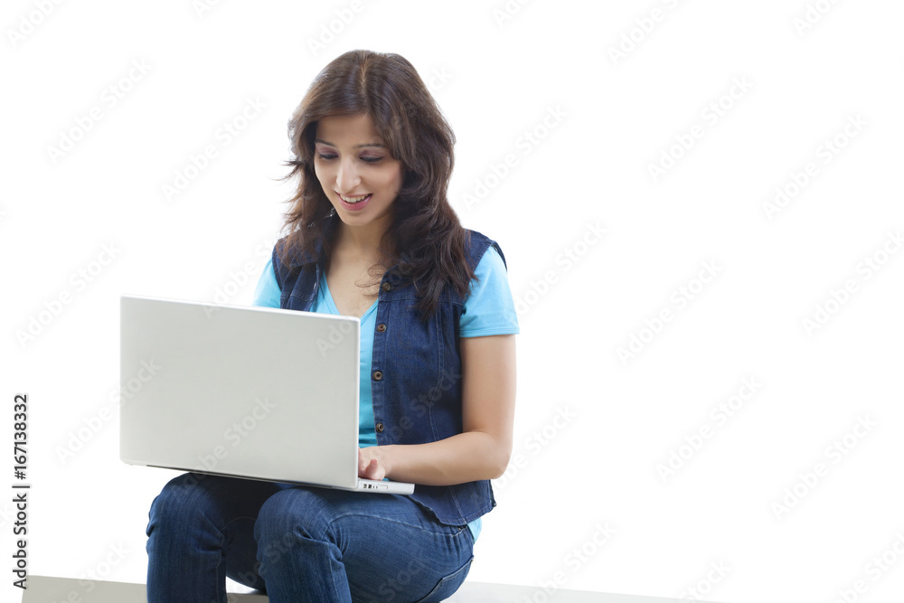 Smiling young woman using laptop over white background Smiling young woman using laptop over white background