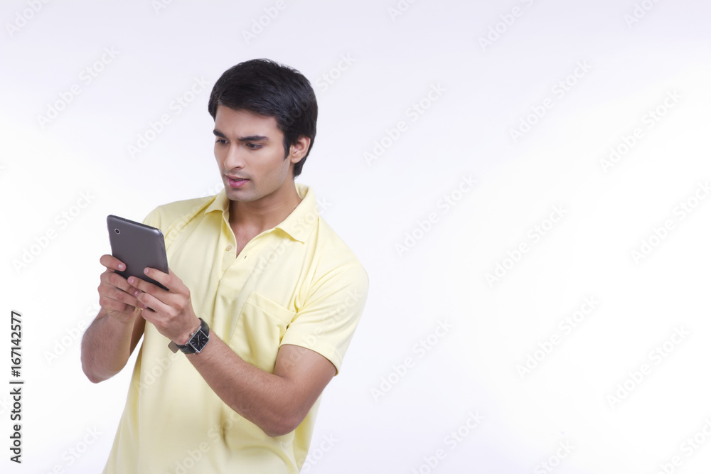 Handsome young man using tablet computer over white background Handsome young man using tablet computer over white background