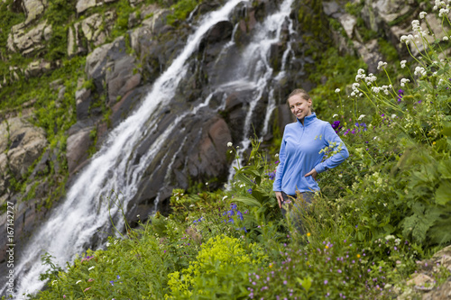 Young hiking woman at a mountain waterfall