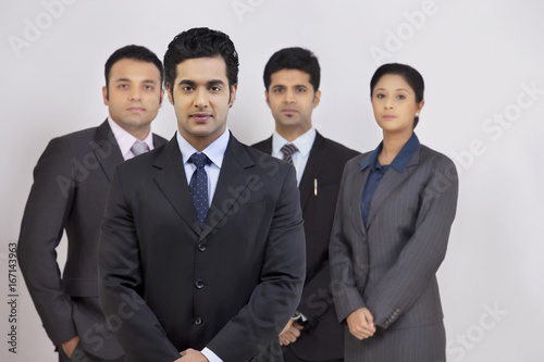 Portrait of confident business people standing against gray background 