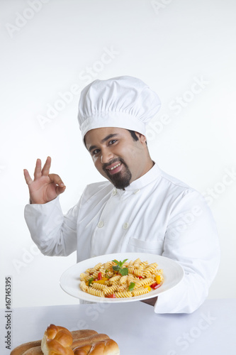 Portrait of chef with plate of pasta