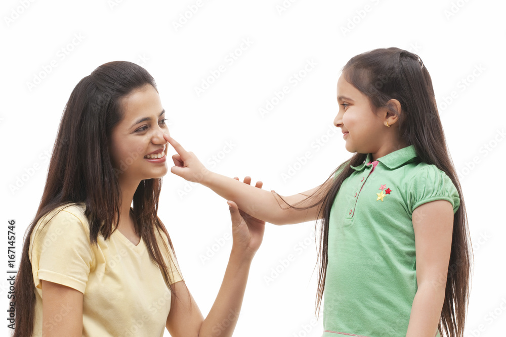 Cute little girl touching mother's nose over white background Cute little girl touching mother's nose over white background