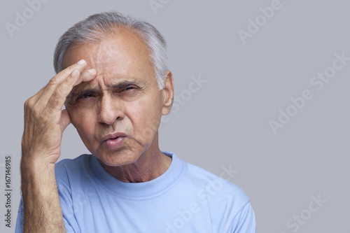 Close-up of senior man suffering from headache 