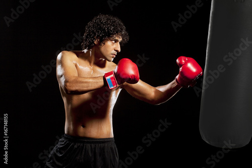 Young man holding punching bag  © IndiaPix