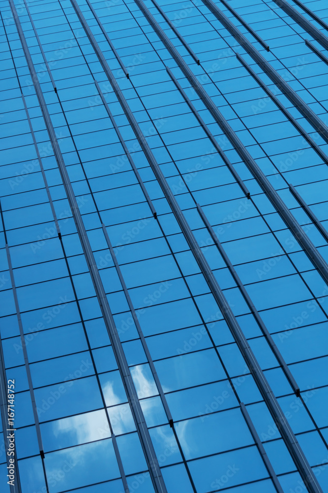 Glass facade of a building with a reflection of the sky with a cloud Glass facade of a building with a reflection of the sky with a cloud