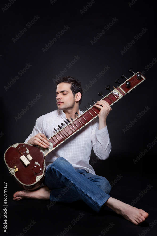 Obraz premium Young man playing the sitar