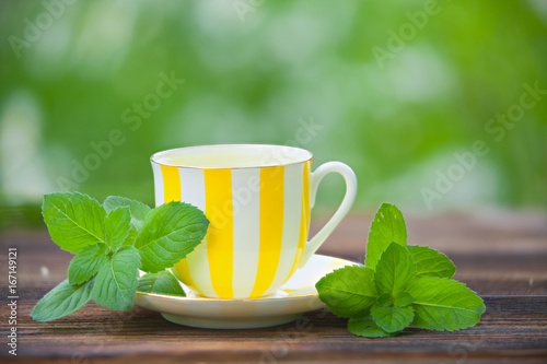 porcelainl cup with green tea on table