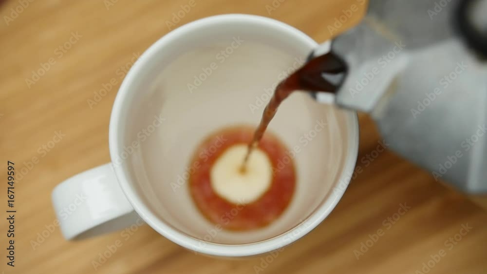 Coffee being poured into coffee cup. Shallow depth of field. Slow Motion.