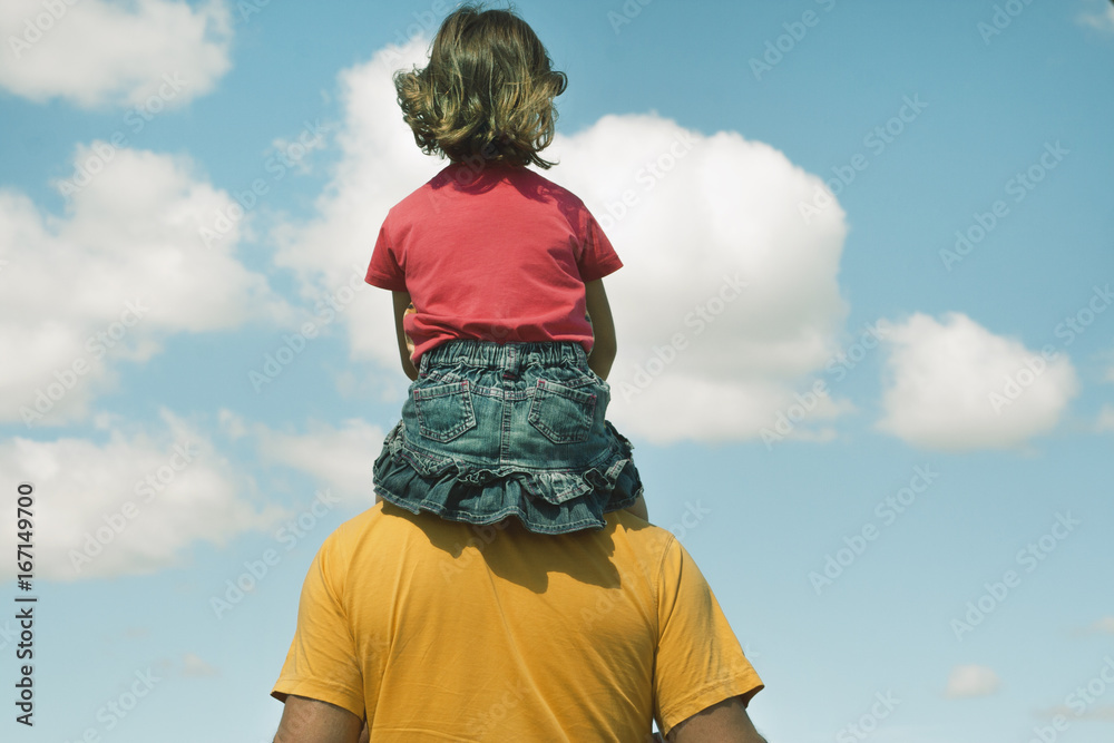 Dad carries daughter on shoulders