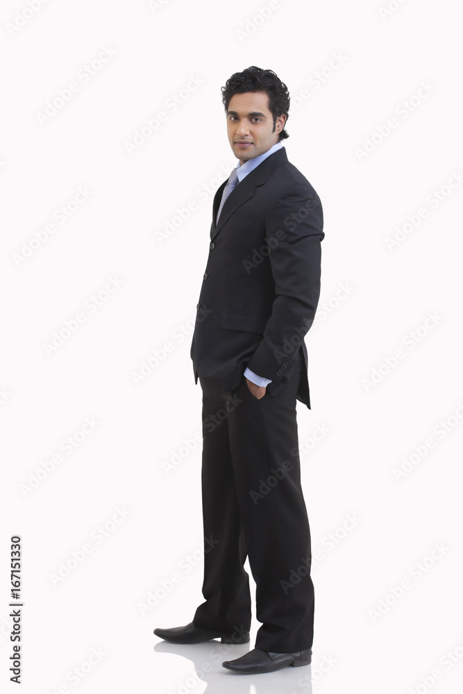 Side view of young businessman with hand in pocket against white background Side view of young businessman with hand in pocket against white background
