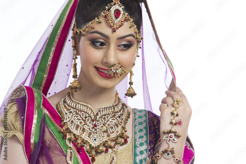 Shy Indian bride looking away against white background