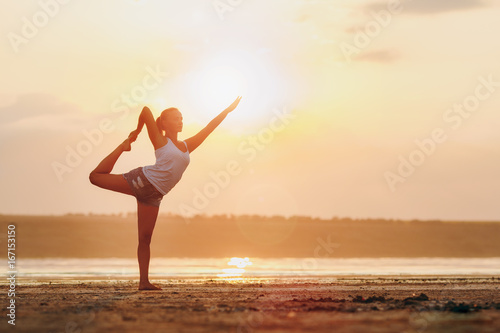 Pretty woman doing yoga at sunset outdoors © ViDi Studio