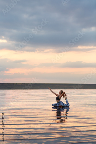 Pretty woman doing yoga at sunset outdoors © ViDi Studio