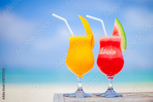 Two cocktails of watermelon and mango on background of stunning turquoise sea