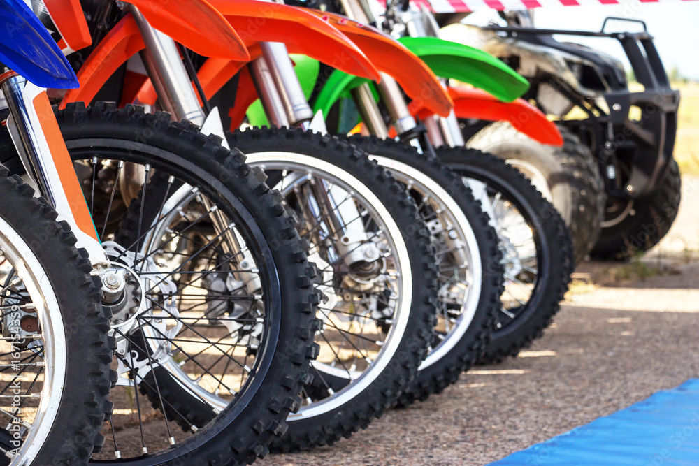 Motocross bike stand in a row. Motocross tires and wheels Motocross bike stand in a row. Motocross tires and wheels