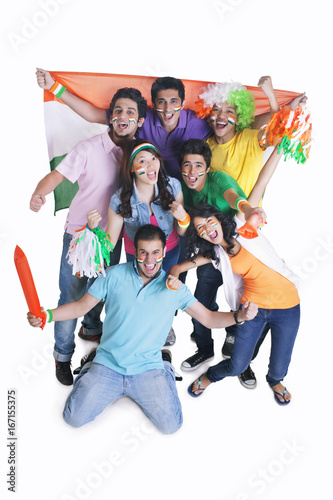 Portrait of happy young friends cheering with Indian flag over white background 