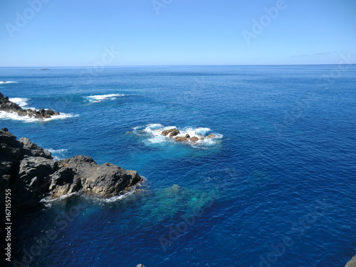 Blue sea with rocks and surf on the coast of Madeira