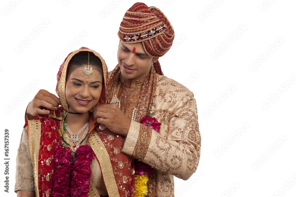 Gujarati groom tying a mangal sutra around brides neck 