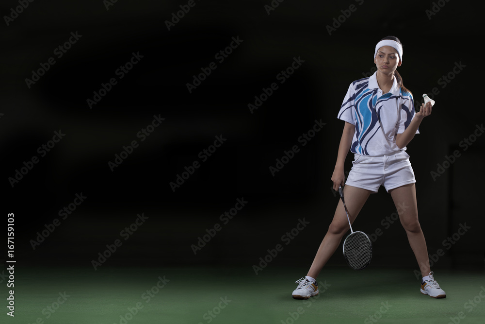 Full length of young woman with badminton racket and shuttlecock