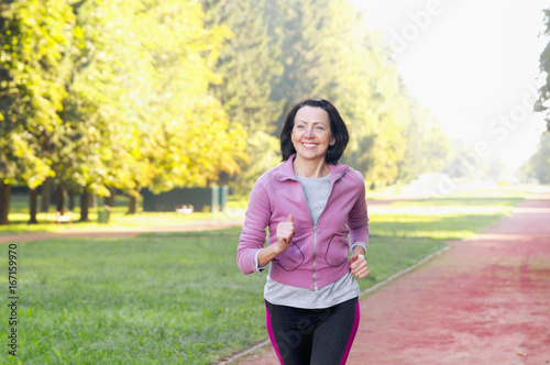 Portrait of elderly woman running in the park
