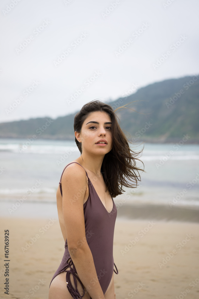 Portrait of beautiful woman in swimsuit standing on beach Portrait of beautiful woman in swimsuit standing on beach