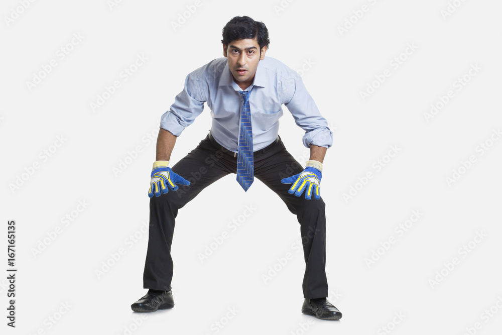 Business goalkeeper ready to save the goal over white background 