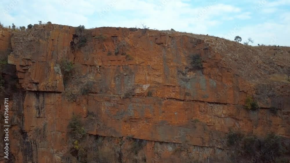 Medium pan shot of dry cliff face with red rocks in Mpumalanga South Africa Medium pan shot of dry cliff face with red rocks in Mpumalanga South Africa