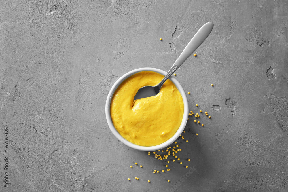 Bowl with delicious mustard sauce and spoon on table Bowl with delicious mustard sauce and spoon on table