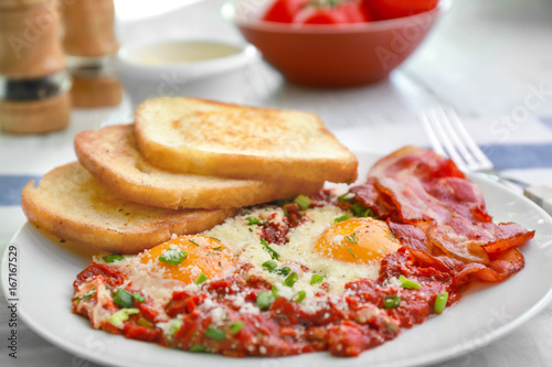 Plate with eggs in purgatory on table