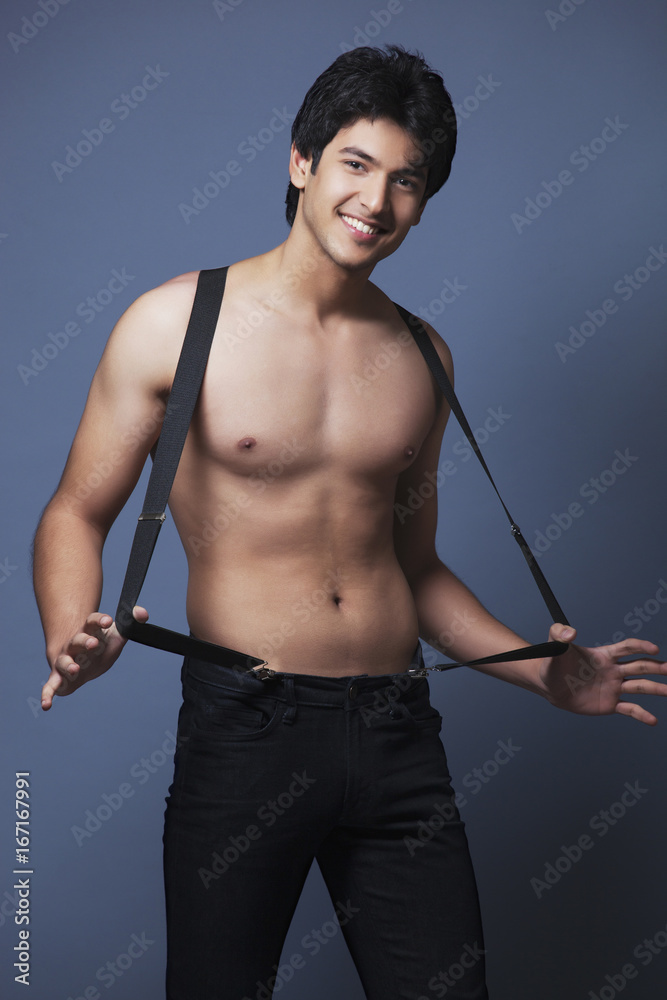 Fototapeta premium Shirtless man wearing suspenders