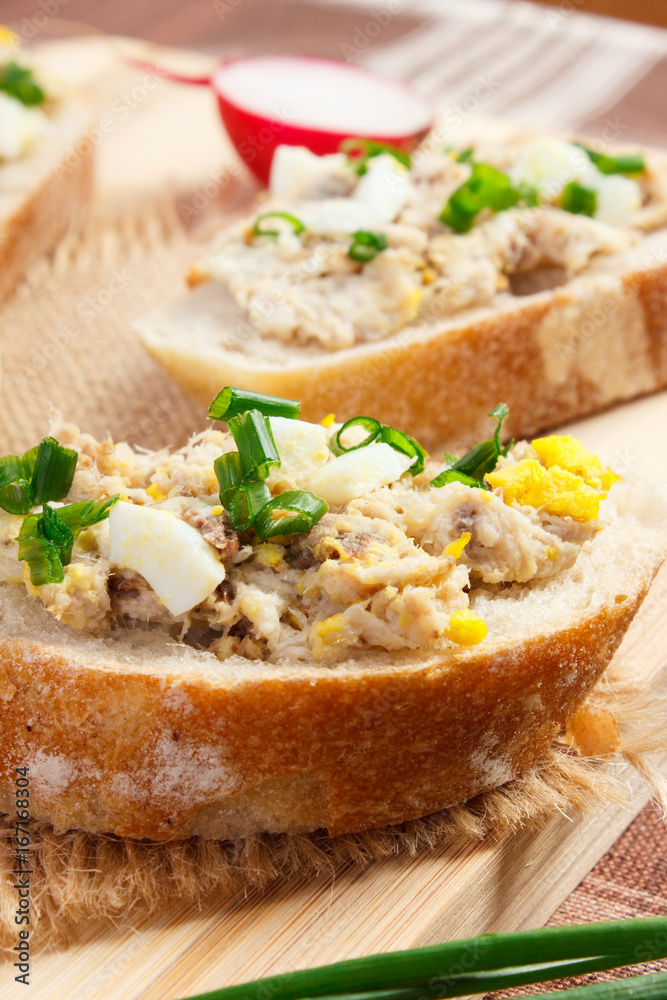 Closeup of crispy baguette with mackerel or tuna fish paste, healthy nutrition Closeup of crispy baguette with mackerel or tuna fish paste, healthy nutrition